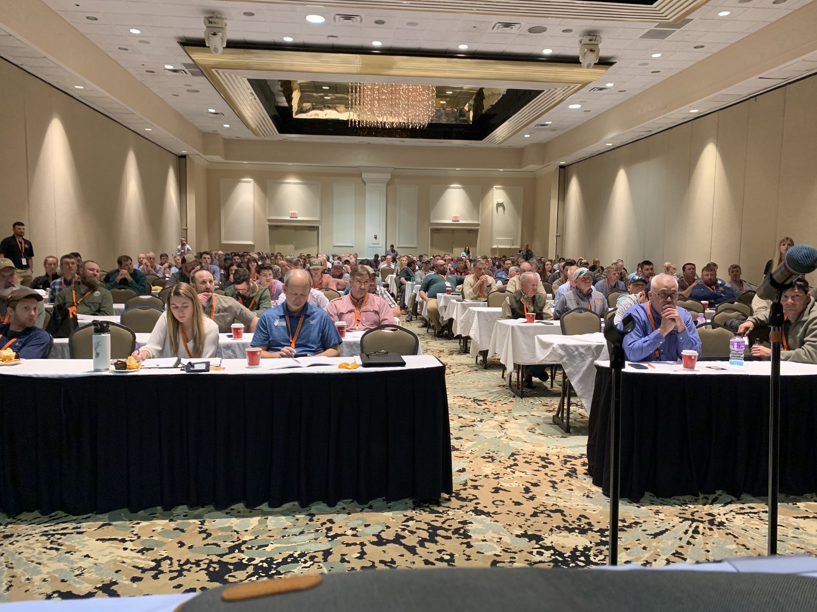Large indoor workshop audience facing the stage