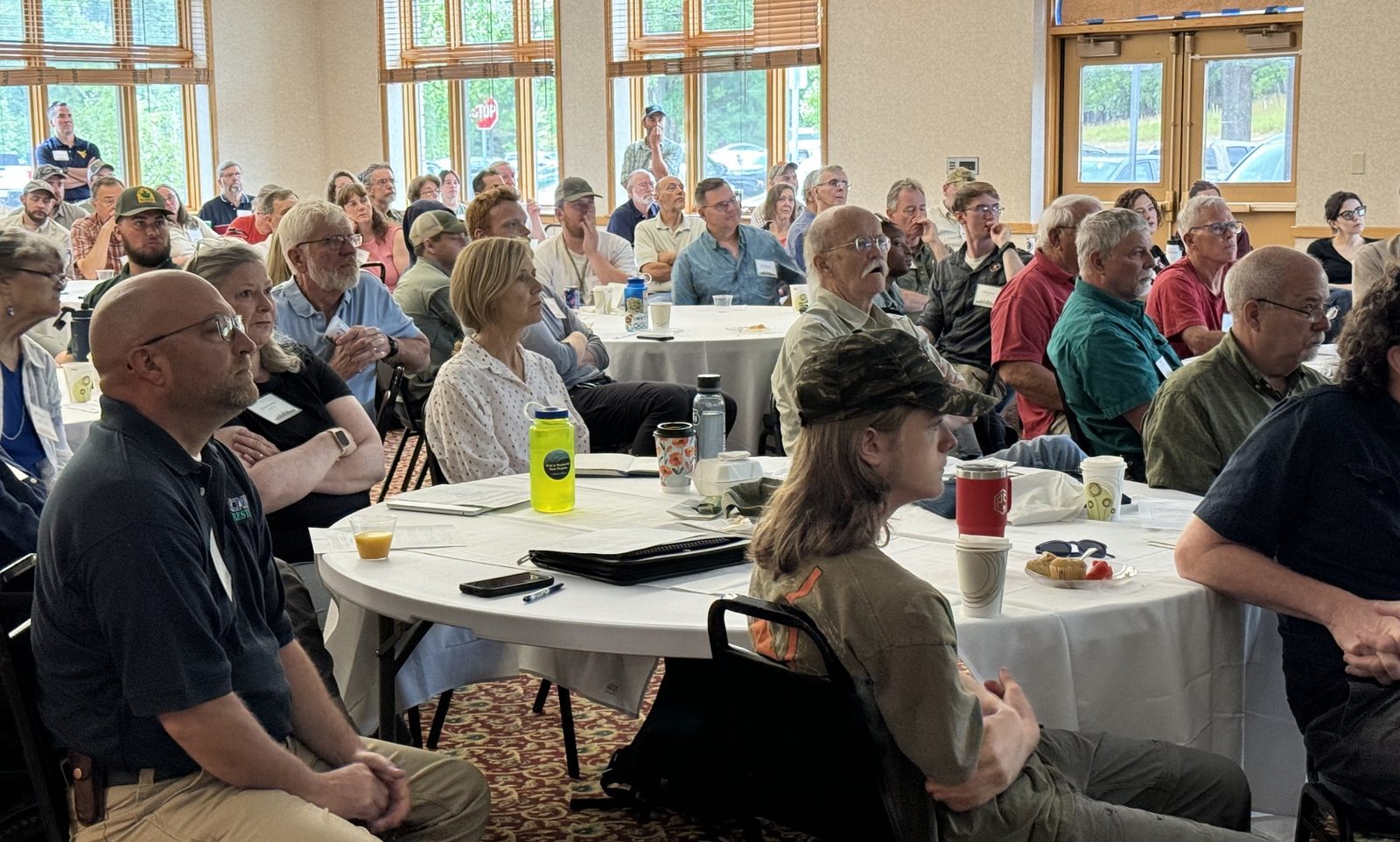 Attentive audience at round tables during a workshop